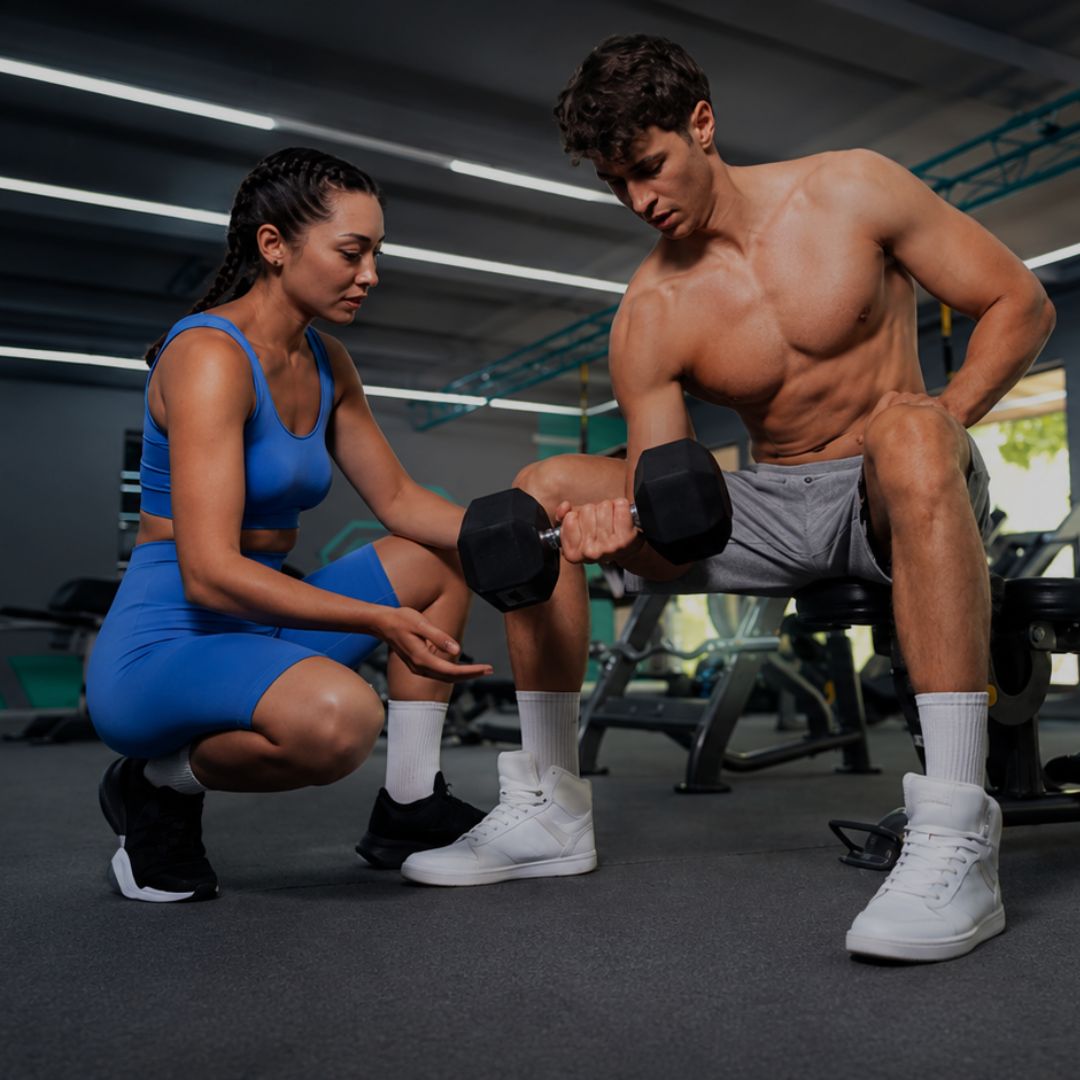 Two people working out together with dumbbells in a gym setting.